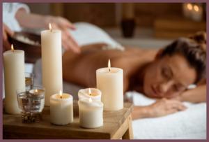 Young beautiful girl relaxing in spa salon. Focus on candles.